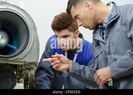 airplane service team repairing plane in hangar Stock Photo