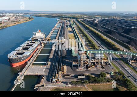 25 April 2021 - Newcastle, NSW, Australia. Aerial view of Japanese bulk carrier NAGARA MARU being loaded with coal and coal loading structures. Stock Photo