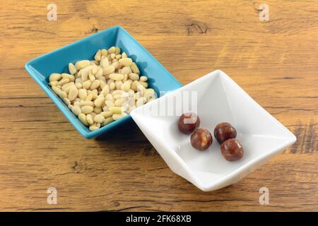 Pine nut hard candy in white candy dish with pine nuts in blue snack dish Stock Photo
