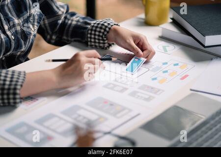 Close up App developer Ux Ui designing with paper model on mobile application prepare Stock Photo