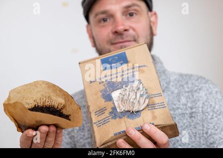 Nuremberg, Germany. 19th Apr, 2021. Ralph Haydl holds a coffee filter with old coffee grounds in one hand and a mushroom growing kit with pigeon blue oyster mushrooms in the other - a mushroom substrate consisting of coffee grounds with mushroom spawn. The 41-year-old from Nuremberg has been selling mushroom cultivation sets for several years, with which one can grow various oyster mushrooms, yellow lemon mushrooms or pink rose mushrooms at home. (to dpa "Delicious mushrooms on old coffee - niche or trend?") Credit: Daniel Karmann/dpa/Ģ����ý Live News Stock Photo