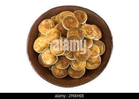 Clay bowl full of Jaggery sugar made of Asian Palmyra Palm sap filled in slices of small dried palm leaves, isolated on white background Stock Photo