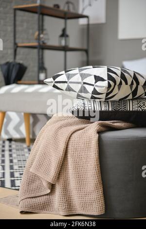 Ottoman with pillows and blanket in interior of modern bedroom Stock Photo