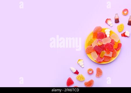 Plate with sweet jelly candies on color background Stock Photo