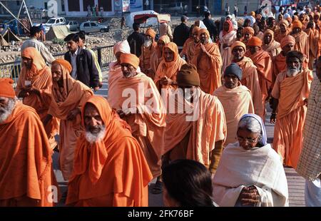 13.03.2010, Haridwar, Uttarakhand, India, Asia - A group of male pilgrims dressed in orange-coloured garments on their way to the holy Ganges River. Stock Photo