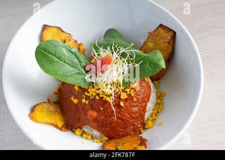 Isolated bowl of Cuban rice with fried plantain. Stock Photo