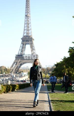 Caucasian blonde girl walking near Eiffel Tower in Paris, France. Stock Photo