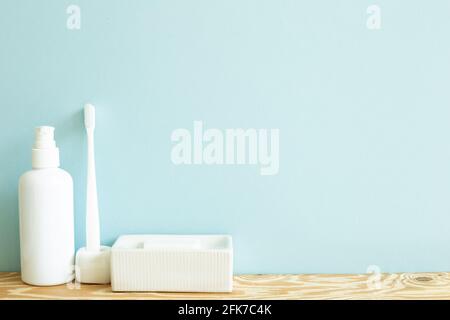 Skin care and spa concept. Bathroom bottle and toothbrush, soap on wooden shelf. sky blue background Stock Photo