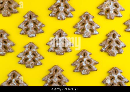 Christmas tree cookies on wooden background. New Year's food. Festive baked goods. Gingerbread on the table. Icing sugar sweetness taste season. Pattern. Stock Photo