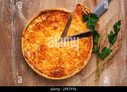 Traditional vegetable pie on rustic wooden table. Sliced slice of pie stuffed with mushrooms and cheese. Close up. Selective focus. Stock Photo