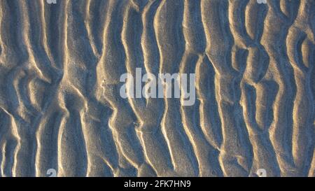 Natural sand pattern on flat sandy beach during low tide. Stock Photo