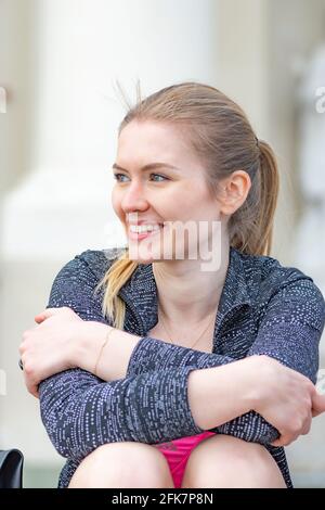Portrait of beautiful lovely young blonde hair girl smiling and enjoying good weather and life in the city, vertical Stock Photo