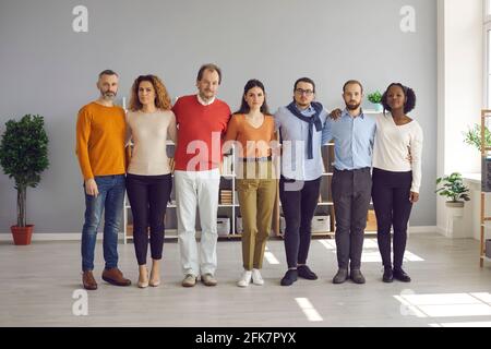 Diverse multiethnic group of adults and young people hug standing in line Stock Photo