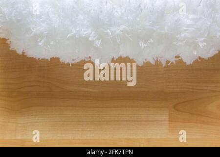 Closeup texture of soft fluffy white cloud like fur microfiber fabric on blurred wooden background Stock Photo