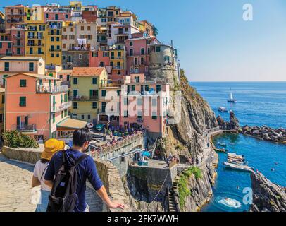 Manarola, La Spezia, Liguria, Italy.  Couple looking out over Manarola, one of the five villages of the Cinque Terre, or Five Lands. The Cinque Terre Stock Photo