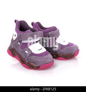 Purple children's girls' boots in sports style isolated on white background. Pair of new modern purple and pink stylish shoes for children with velcro Stock Photo