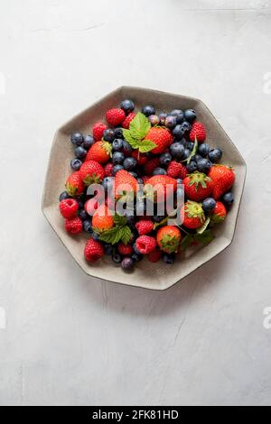 Isolated plate of blueberries, strawberries, raspberries, on delicate background.  Top view. Copy space. Stock Photo