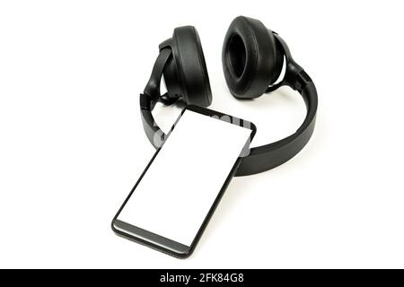 black wireless headphones and smartphone on white background, blank screen mockup, copy space Stock Photo