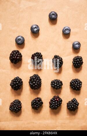 Five blueberries and twelve blackberries on a beige background, laid out in the form of a house. High quality photo Stock Photo