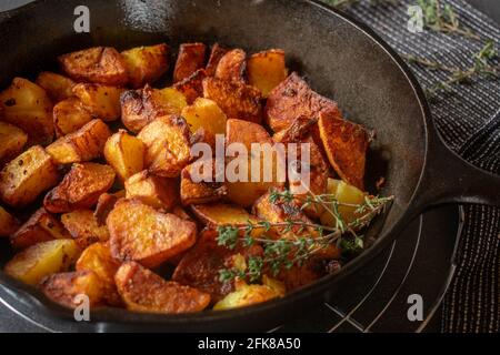 Fresh and homemade fried potatoes in a cast iron pan. closeup view Stock Photo