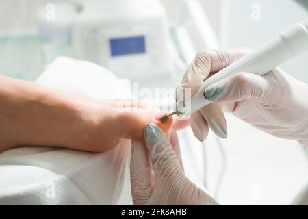 A Podiatrist doctor who takes care of a woman's toenails. Cosmetic procedures of the feet Stock Photo