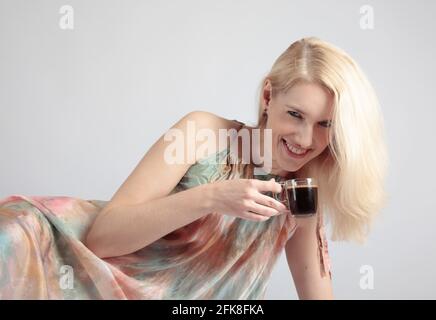 Portrait of a beautiful mid-age woman with cup of coffee. Attractive and happy blonde drinks coffe. Stock Photo