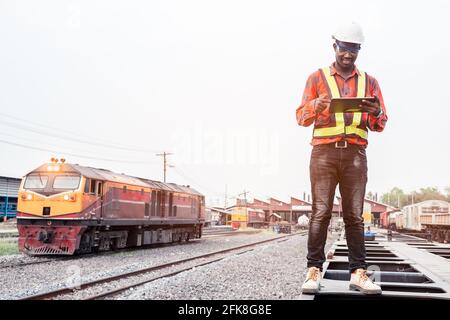 African engineer   control a the train on railway with using tablet Stock Photo