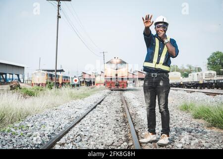 African engineer   control a the train on railway with talking by radio communication or walkie talkie Stock Photo