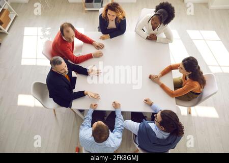Group of company employees discussing work matters at office table in corporate meeting Stock Photo