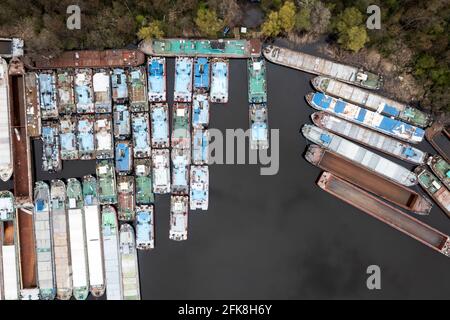 Lots of abandoned transport barges moored side by side at the wharf. River transport industry. Stock Photo