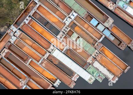 Lots of abandoned transport barges moored side by side at the wharf. River transport industry. Stock Photo