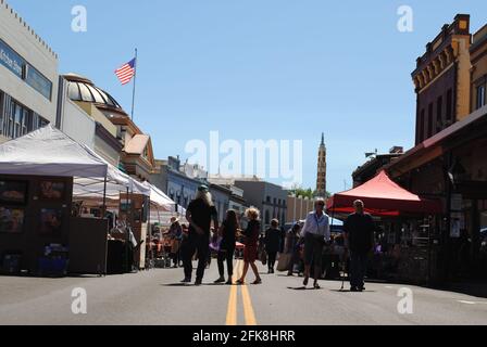 Grass Valley, California: Mill Street is closed off for sidewalk sales in this gold mining town. American flag flying, old buildings, gold rush town. Stock Photo