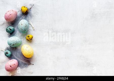 Layout of colorful Easter eggs and birds feather, top view Stock Photo