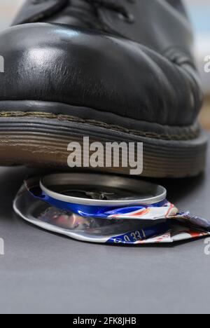 crushing empty beverage can with boot Stock Photo