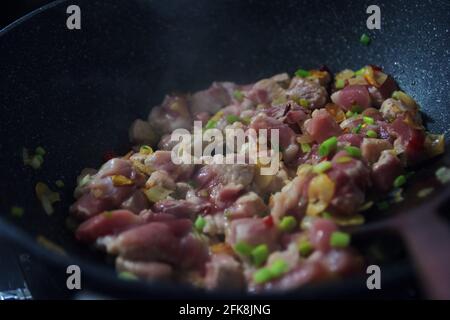 Close-up view of the raw pork in the pan during cooking Stock Photo
