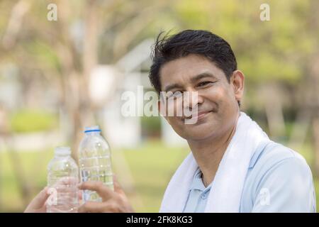 Close up Senior people old man talking and drinking water after exercising in park Stock Photo