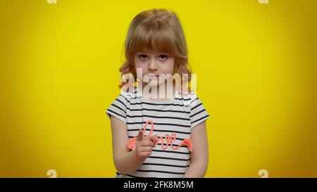 Kid child girl warning with admonishing finger gesture sign, saying no, be careful, avoid danger Stock Photo