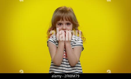 Upset scared child girl biting nails, feeling worried nervous, serious troubles, stress, anxiety Stock Photo