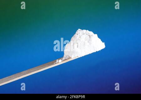 Closeup of white powder looking like drugs in front of a blue background Stock Photo