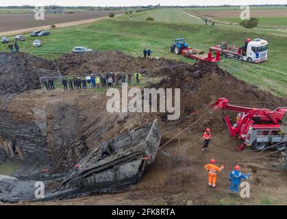 A 26-foot-long Buffalo tank is extracted from the earth in Crowland, Lincolnshire, where it has been buried for 74 years since it was brought into the village to help during heavy floods in March 1947. Sixteen of the amphibious Buffalo tanks were used to help seal the breach when a combination of heavy snow, high tides, rain and wind caused the River Welland to break its banks. Picture date: Thursday April 29, 2021. Stock Photo