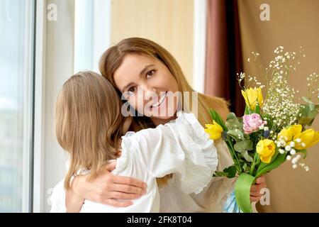 daughter congratulates mom on holiday - mother's day or birthday Stock Photo