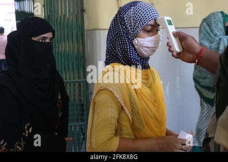 India. 29th Apr, 2021. Thermal screening of voters standing in a queue outside a polling station to cast their ballot during the final phase of West Bengal's state legislative assembly elections in Kolkata on April 29, 2021. (Photo by Dipa Chakraborty/Pacific Press) Credit: Pacific Press Media Production Corp./Alamy Live News Stock Photo