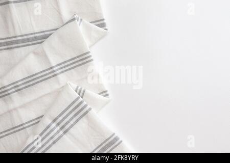 folded grey cotton napkin isolated on white background with copy space, white striped towel, top view Stock Photo