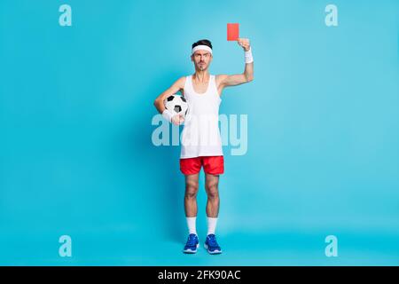 Full length photo of displeased person arm hold ball demonstrate red card isolated on blue color background Stock Photo