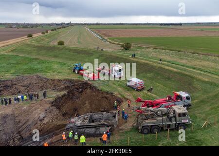 A 26-foot-long Buffalo tank is extracted from the earth in Crowland, Lincolnshire, where it has been buried for 74 years since it was brought into the village to help during heavy floods in March 1947. Sixteen of the amphibious Buffalo tanks were used to help seal the breach when a combination of heavy snow, high tides, rain and wind caused the River Welland to break its banks. Picture date: Thursday April 29, 2021. Stock Photo