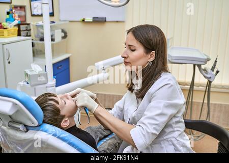 an orthodontist at his workplace examines the patient's oral cavity Stock Photo