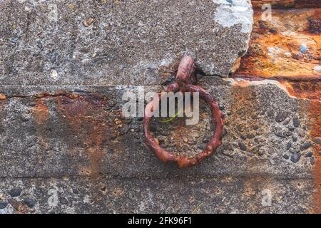 Rusty ring for the mooring of a fishing boat on an old dock Stock Photo