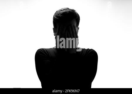 Silhouette of man crying being sad having depression Stock Photo