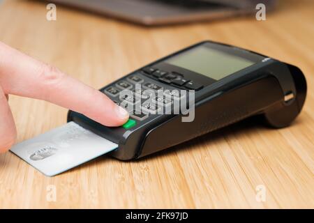 Man hand enters pin code on the terminal for payment. Stock Photo