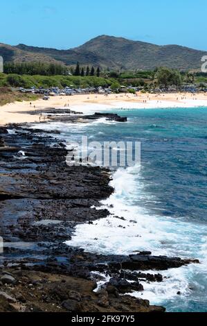 Ocean Waves on Sandy Beach with Mountains in Background, Halona Blowhole Lookout, Honolulu, Hawaii Stock Photo